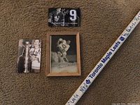 Close-up photo showing the signed hockey stick with 'Toronto Maple Leafs' printed on tape grip, alongside three signed Toronto Maple Leafs player photos including a framed vintage image, Stanley Cup photo, and player card.