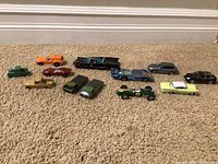 Wide shot of all eleven model cars arranged on carpet showing variety of models, shapes and colors.