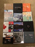 Grid of 12 Canada Post stamp collection albums on carpet