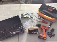 Full view of the lot showing power tools, bits, manual, hand crank tool, and tool bag.