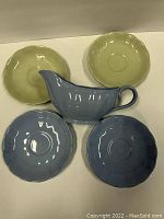 Top view of two mint green side plates and two blue side plates with blue gravy boat centered in front