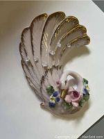 Front view of the swan figurine showing floral decorations and gold accents on wings and neck.