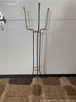 Full front view of the brass plant stand showing overall shape and height.