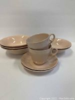 Group photo of three pink Petal Ware bowls and two pink teacups stacked on their matching saucers.