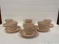 Photo showing all six tea cup and saucer sets arranged in two rows.
