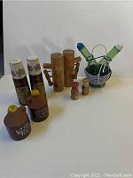 Vintage salt and pepper shakers in multiple styles and materials including ceramic, wood, glass, and metal basket holder.