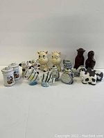 Multiple sets of ceramic salt and pepper shakers with various animal and character designs including dog, fish, cow, cat, etc.