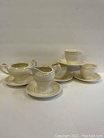 Overall lot showing all pieces: 3 cups and saucers, creamer, sugar dish