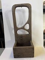 Front view of vintage wooden planter showing rectangular box base and tall backrest with decorative irregular cutouts.