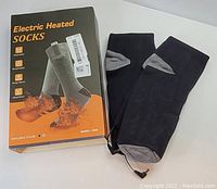 Photo showing the box and the black/grey electric heated socks laid out next to it.