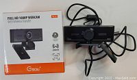 Black Gsou webcam with manual focus and built-in mic with its original box showing wireless transfer and tripod support features.