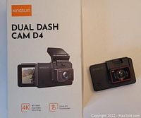 Kingslim Dual Dash Cam D4 placed beside its original packaging box showing front and rear camera details, 4K+1080P dual video recording, 3-inch IPS touchscreen, and brand logo.