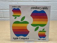 Four Apple Computer rainbow logo decals on white backing, various sizes, showing front view