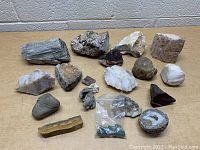 Top view of lot of various rocks and minerals on a cardboard surface showing stone textures and colors.