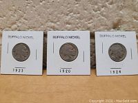 Front view showing three Buffalo nickels dated 1923, 1920, and 1924 in individual cardboard holders.