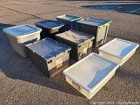 Photo showing all 8 storage bins lined up outdoors in daylight, highlighting the variety of sizes and lid types.