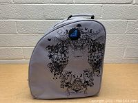 Front view of the light purple Roxy insulated cooler bag showing the detailed black floral skull design and blue Roxy logo patch.