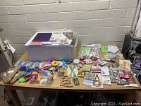 Overview of Sterilite drawer and assorted craft supplies spread out on table showing variety of items and packaging