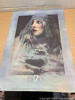 Full poster on a wooden surface showing the entire artwork and text at the bottom.