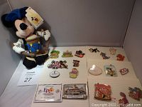 Plush Mickey Mouse doll and various Disney pins on display board