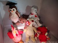 Six new with tag Beanie Babies including an owl, bear, fox, pink flamingo, sloth, and lobster arranged in a white background