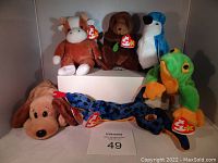 Six Ty Original Beanie Babies plush toys displayed on and around a white box, showing front and side views with tags attached.