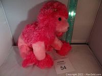 Pink poodle plush toy, shown sitting next to a measuring ruler for scale. Red Ty tag visible on the ear.