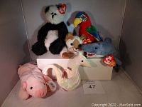 Seven assorted Ty Beanie Babies plush toys arranged with visible original heart-shaped Ty tags showing "NWT" condition