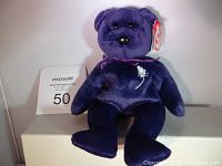 Front view of original purple Princess Diana Beanie Baby teddy bear plush, showing full body and original Ty tag on ear.