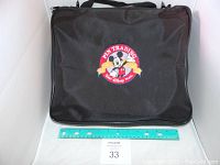 Front of black Disney Pin Trading bag with Mickey Mouse patch and ruler for size reference.