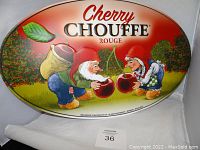 Oval metal tin bar sign featuring Cherry Chouffe Rouge beer advertisement with two gnome-like characters holding cherries.