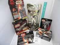 Full view of Star Wars collectibles set including boxed Episode I Darth Maul figure, LEGO set, Stormtrooper in display case, erasers and blaster.