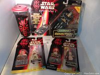 Photo showing the Star Wars Episode I CommTech reader, Obi-Wan Kenobi and Qui-Gon Jinn figures with CommTech chips and Darth Maul cup.