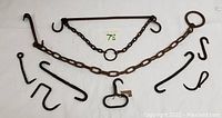 Full set of antique cast iron ranch/kitchen tools comprising chains with hooks, rods, and separate hooks.