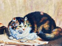 Close view of the calico cat figure lying down with eyeglasses, showing detailed brushwork and coloration.