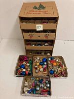 Overall view of four cardboard boxes labeled Christmas Storage Box containing assorted vintage Christmas ornaments in various shapes and colors.