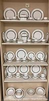 Full set displayed on shelves across four rows, showing a complete service with plates, cups, saucers and serving pieces