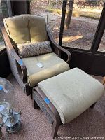 Front view of chair and ottoman showing frame, cushions, and lumbar pillow