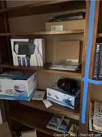 Shelving unit with boxes of VuPoint photo scanning equipment, providing overview of the lot