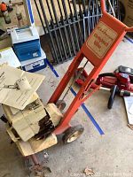 Full view of Gilson compact tiller showing orange metal frame, wheels, and white motor housing with attached manual.
