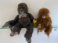 Full view of the three Steiff plush animals sitting on a shelf: gorilla, monkey, frog.