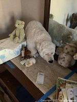 Overview of all five Steiff plush animals displayed on a table, including Lysander bear on its box, polar bear, giraffe, bird, and mouse.