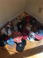 Collection of various baseball caps including Guinness cap, denim cap, and caps with embroidered logos and souvenir pins