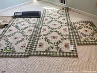 Three matching Safavieh rugs laid out on a carpeted floor showing the bee motif and green checkerboard frame border.