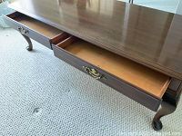 Close-up of the two drawers open showing interior made of wood and brass-toned handles.