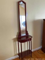 Full view of the wooden hall table with tall attached mirror, showing the overall shape, mirror, shelf, and drawer.