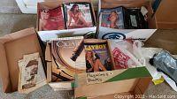 Photo showing several boxes of vintage magazines including Playboy and Cigar Aficionado with label 'Magazines & Books'.