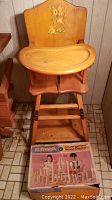 Vintage wooden high chair with Bambi illustration on the backrest, front view with tray and footrest visible