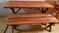 Wooden picnic table with two benches, showing overall view and wood plank surface.
