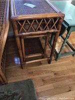 Side view of one smaller rattan end table showing rattan frame and woven top
